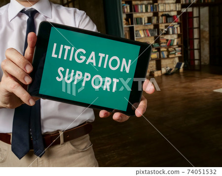 Lawyer holds a tablet with litigation support. Lawyer holds a tablet with litigation support. 74051532