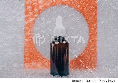 Mockup of dropper bottle with modern organic cosmetics - polyglutamic or hyaluronic acid, serum, moisturizer, facial anti-aging oil. Trendy gray and orange still life composition, selective focus Mockup of dropper bottle with modern organic cosmetics - polyglutamic or hyaluronic acid, serum, moisturizer, facial anti-aging oil. Trendy gray and orange still life composition, selective focus 74051634