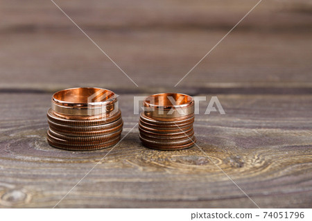 Stacks of coins and golden rings. 74051796