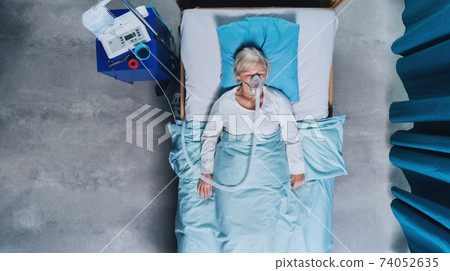 Top view of covid-19 patient with oxygen mask in bed in hospital, coronavirus concept. 74052635