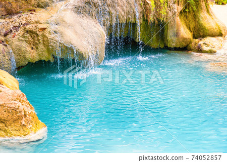 Tropical waterfall with emerald blue lake and rocks in jungle forest Tropical waterfall with emerald blue lake and rocks in jungle forest 74052857
