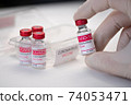 Closeup doctor hand holding a glass bottle of coronavirus vaccine. Concept of coronavirus vaccination. Macro 74053471