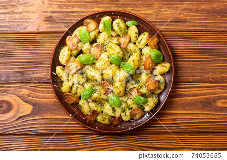Homemade potatoes gnocchi with basil , cheese and mushrooms Homemade potatoes gnocchi with basil , cheese and mushrooms 74053685