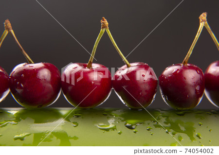 fresh cherry berry with water droplets on a green bottle. healthy food for breakfast. fresh cherry berry with water droplets on a green bottle. healthy food for breakfast. 74054002