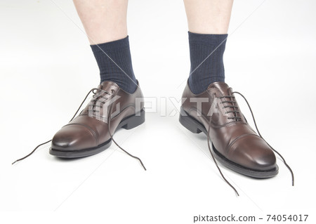 Male legs in socks and brown classic shoes on a white background 74054017
