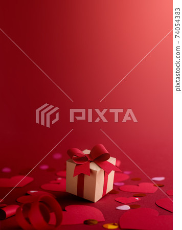 Paper art Valentine's day concept banner with hand made gift box, paper cut ribbon, bow, and a lot of hearts. against dark red background with empty space for text. 74054383