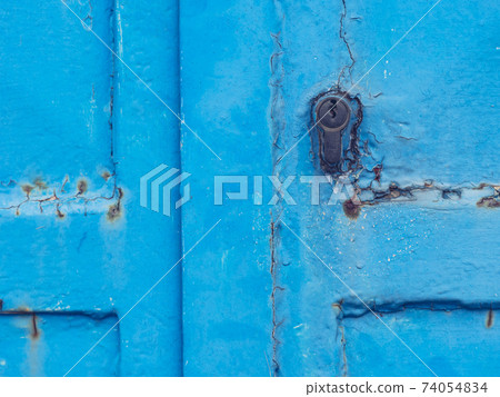 Blue metal door in building wall. Detail of locking system 74054834