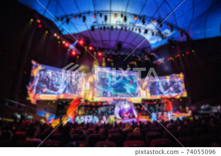 Blurred background of esports event at big arena with a lot of lights and screens. 74055096