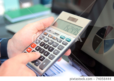Businessman / accountant is doing calculations. Tax season. Businessman / accountant is doing calculations. Tax season. 74056444