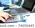 Businessman / accountant is doing calculations. Tax season. 74056445