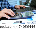 Businessman / accountant is doing calculations. Tax season. 74056446