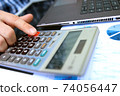 Businessman / accountant is doing calculations. Tax season. 74056447