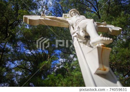 Low angle view of Crucified Jesus cemetery statue with copy space. Low angle view of Crucified Jesus cemetery statue with copy space. 74059631