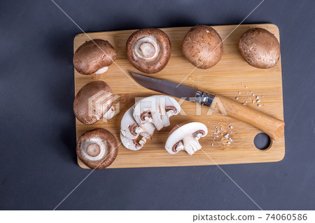 Parisian champignons, mushrooms on wooden chopping board. Parisian champignons, mushrooms on wooden chopping board. 74060586