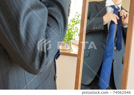 一個商人的修飾檢查圖像穿在鏡子前面的衣服的一條領帶 74062846