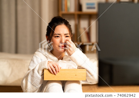 Young woman crying watching a drama at night 74062942