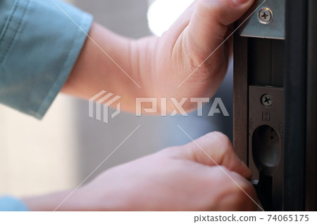 Male repairman maintaining the front door Male repairman maintaining the front door 74065175