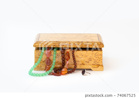 Jasper, agate and nephritis beads in wooden jewelry box and silver ring with amber isolated on white Jasper, agate and nephritis beads in wooden jewelry box and silver ring with amber isolated on white 74067525
