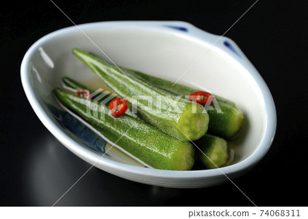 Shooting spicy white pickled okra on a black background Shooting spicy white pickled okra on a black background 74068311