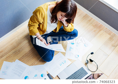 Young woman doing unfamiliar teleworking at home 74068323