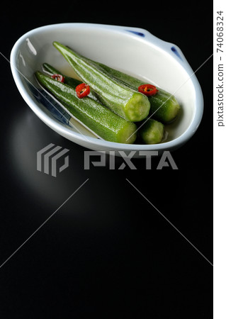Shooting spicy white pickled okra on a black background 74068324
