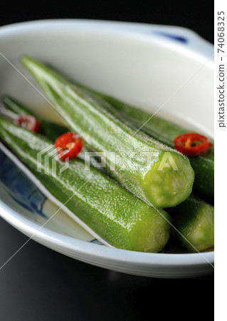 Shooting spicy white pickled okra on a black background 74068325