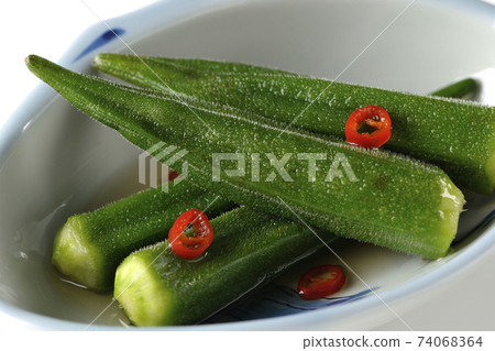 Shooting spicy white pickled okra on a white background Shooting spicy white pickled okra on a white background 74068364