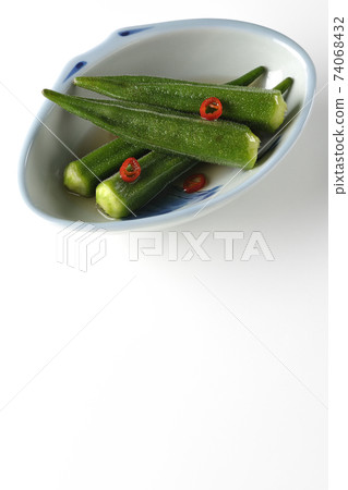 Shooting spicy white okra pickles on a white background (overhead view) 74068432