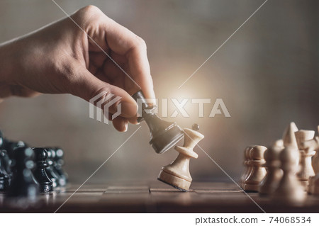 Black pawn beating white queen on chessboard 74068534