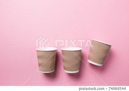 Paper cup for hot coffee or tea on a pink isolated background. Paper cup for hot coffee or tea on a pink isolated background. 74068544