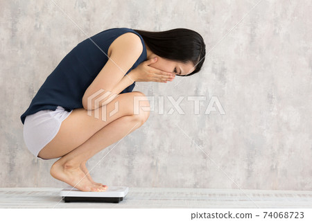 Woman measuring weight Woman measuring weight 74068723