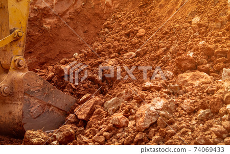 Backhoe bucket digging the soil at agriculture farm to make pond. Crawler excavator digging at shale layer. Excavating machine. Earth moving equipment. Excavation vehicle. Construction business. 74069433