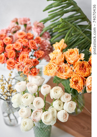 Set of white, green and orange flowers for Interior decorations. The work of the florist at a flower shop. Fresh cut flower. 74070436