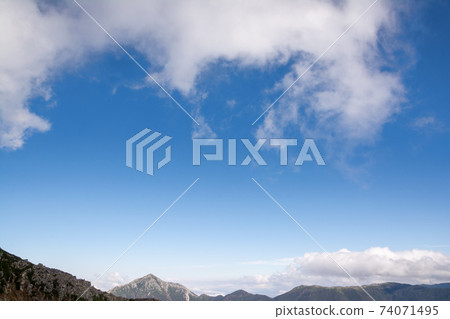 從信州北阿爾卑斯山的穗高山看到的喬嫩山。藍天,白雲。 從信州北阿爾卑斯山的穗高山看到的喬嫩山。藍天,白雲。 74071495