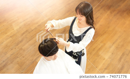Hair stylist who cuts the customer's hair 74071776