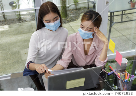 Asian Business Team Meeting Brainstorming Business start up working at Private Home Office social distancing among Coronavirus outbreak New generation business people meeting analysis work from laptop 74071958