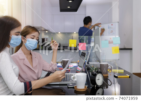 Asian Business Team Meeting Brainstorming Business start up working at Private Home Office social distancing among Coronavirus outbreak New generation business people meeting analysis work from laptop 74071959