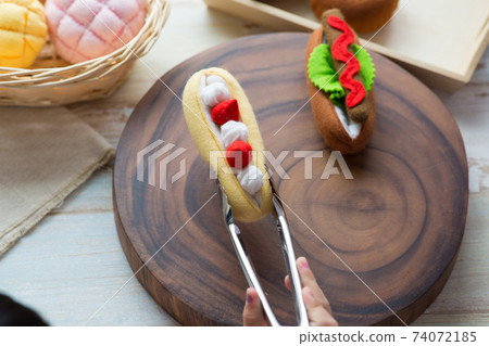 Children's hands playing with felt bread 74072185