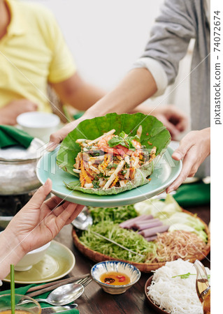 Woman giving salad to guests 74072674