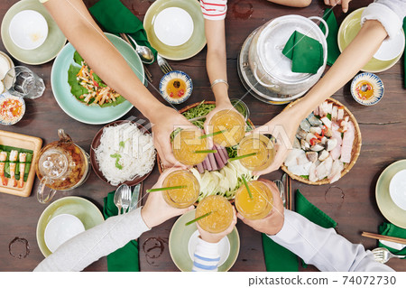 Family members toasting over table 74072730
