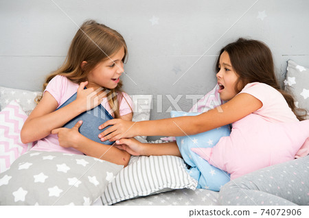 Kids lay in bed fight for book. Friends have some problems. 74072906