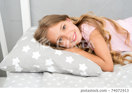 Good morning. Girl child long hair lay awake close up.  74072913