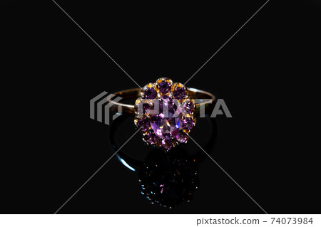 Beautiful golden ring with purple gemstone isolated on black background Beautiful golden ring with purple gemstone isolated on black background 74073984