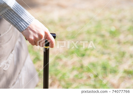A woman's hand walking with a cane A woman's hand walking with a cane 74077766