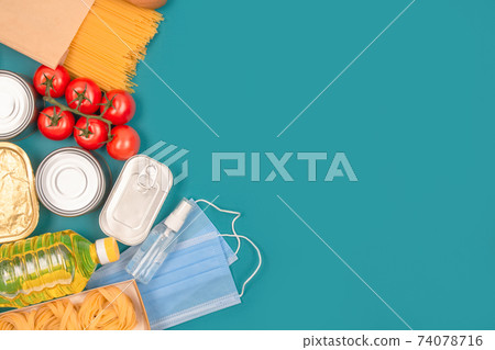 Food and medicine donations on green background with copy space - pasta, fresh vegatables, canned food, baguette, disposable face mask and hand sanitazer spray bottle. Food bank, food delivery concept Food and medicine donations on green background with copy space - pasta, fresh vegatables, canned food, baguette, disposable face mask and hand sanitazer spray bottle. Food bank, food delivery concept 74078716