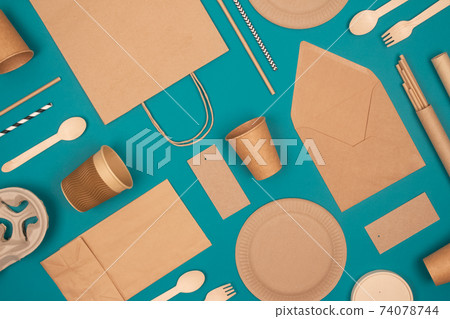 Flat lay with eco-friendly tableware - kraft paper food packaging on green background. Street food paper packaging, recyclable paperware, zero waste packaging concept. Mockup, selective focus 74078744