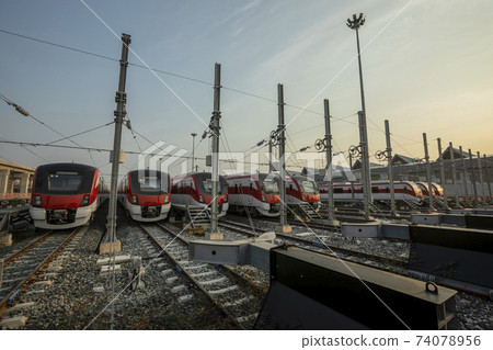 Railway Station with sunlight cast on trains parking by the platform. 74078956