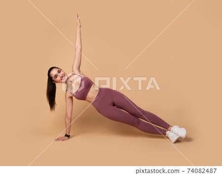 Smiling Young Woman Doing Side Plank Balance Exercise Smiling Young Woman Doing Side Plank Balance Exercise 74082487