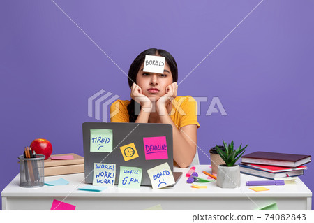 Tired indian woman sitting at desk with sticky notes 74082843