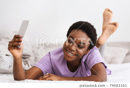 Selfies in bed for social networks and great mood in morning at weekend 74083161